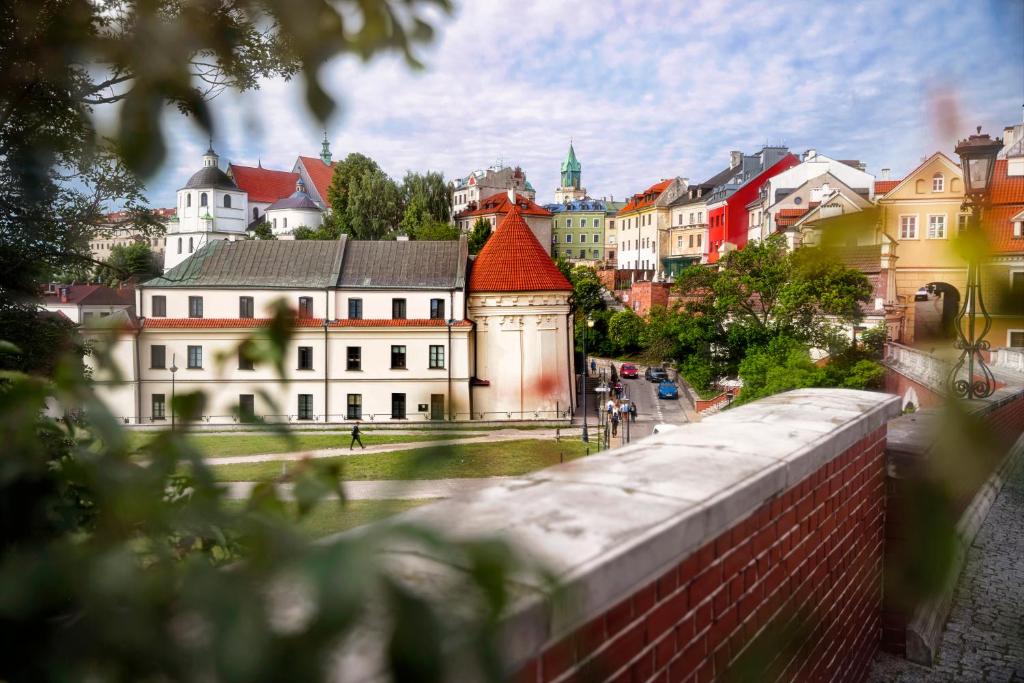 uma vista para uma cidade com edifícios e uma parede de tijolos em Dom na Podwalu em Lublin