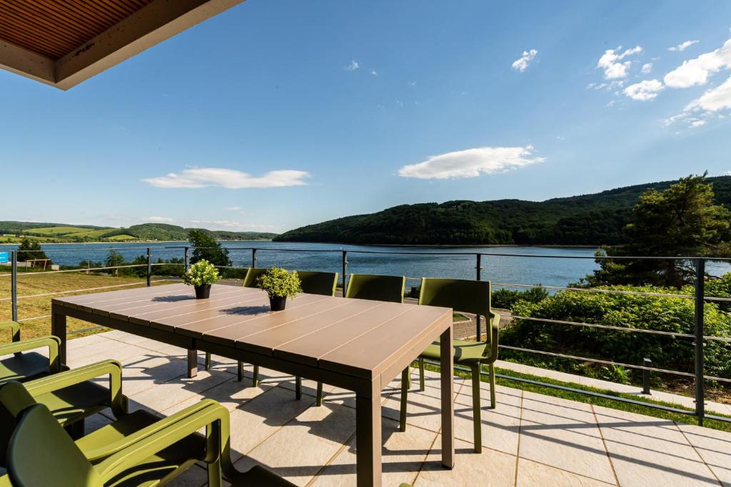 a table and chairs on a patio with a view of the water at CHATA PANORAMA DOMAŠA in Valkov