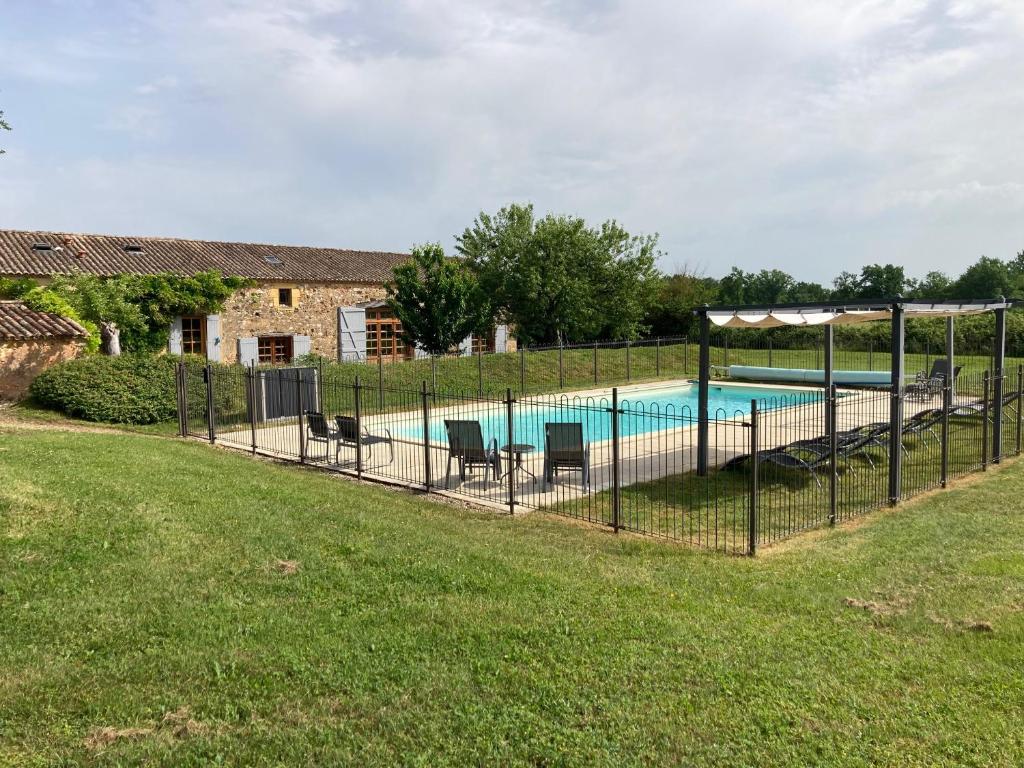 a fence around a swimming pool in a yard at Lueurs de Gorce in Barjou