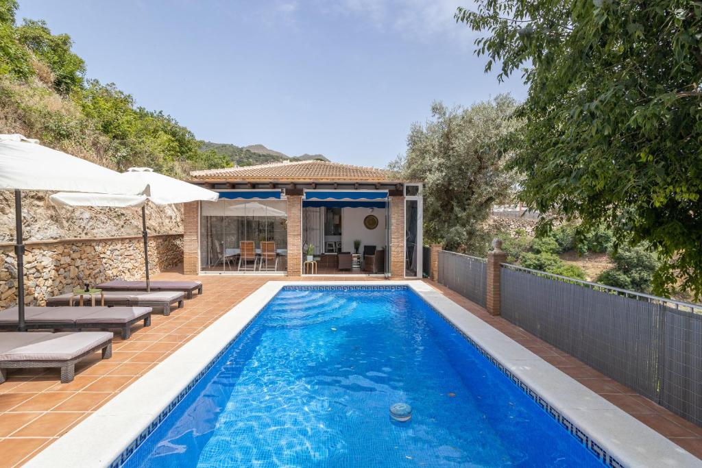een zwembad met een patio en een huis bij Casa Flamenca in Canillas de Albaida