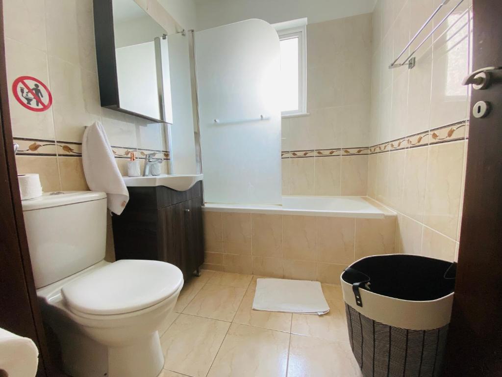 a bathroom with a toilet and a sink and a tub at Apollo 2-BR Apt in Larnaca in Larnaca