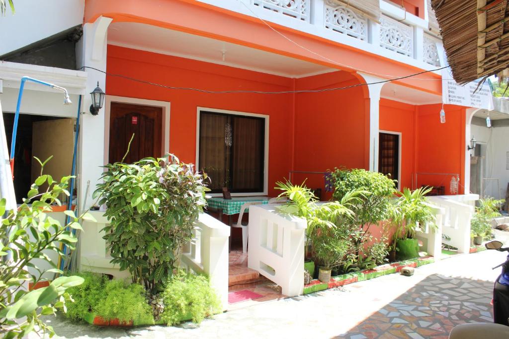 una casa roja con plantas delante de ella en M&E Guesthouse, en Boracay