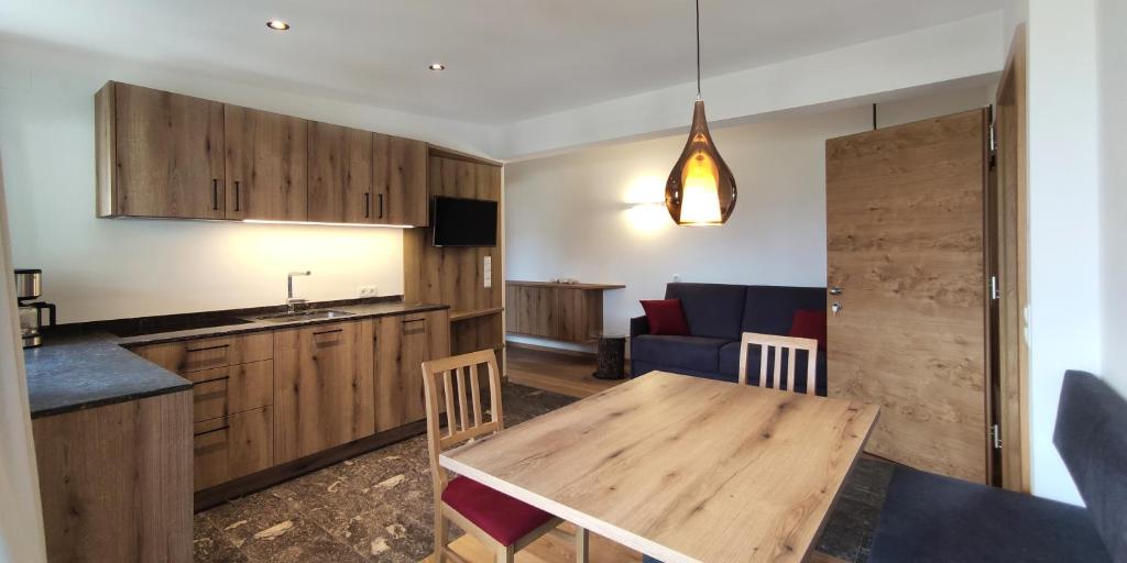 a kitchen with a wooden table and a blue couch at Mittelbergerhof Ferienwohnungen in Vilpiano