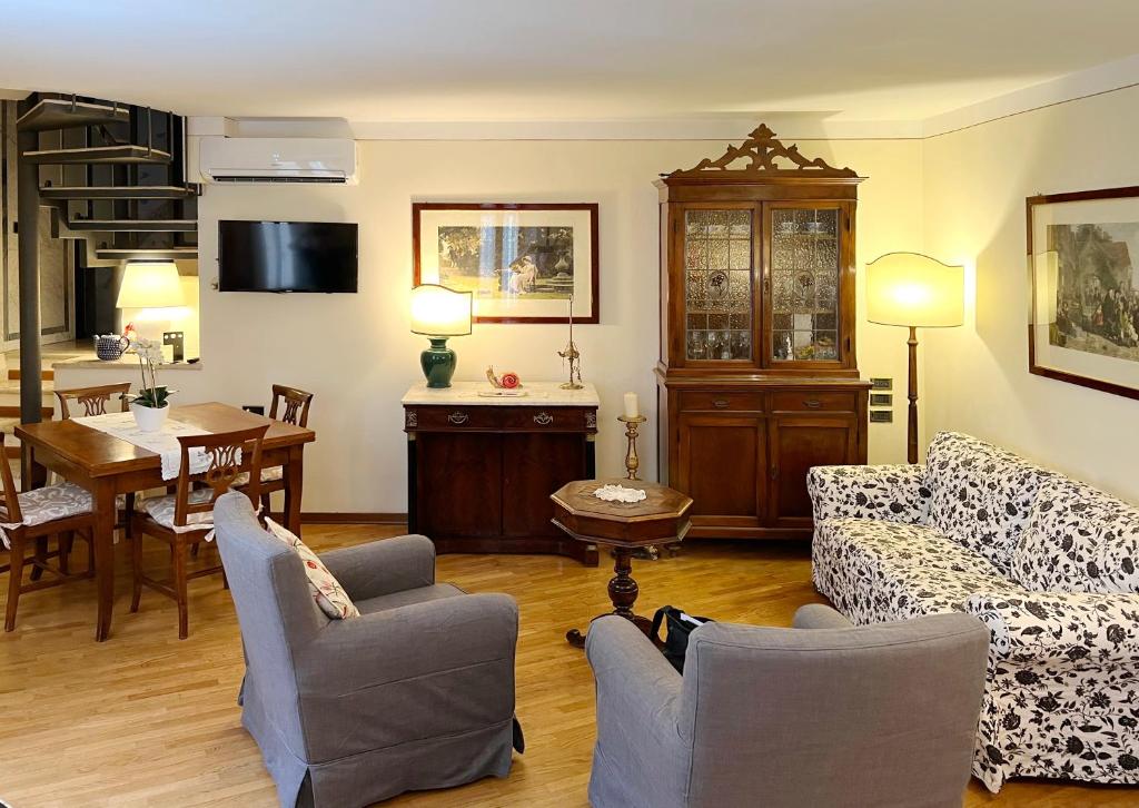 un soggiorno con divano, sedie e tavolo di LADYHOUSE Appartamento tipico con 4 posti letto a Siena