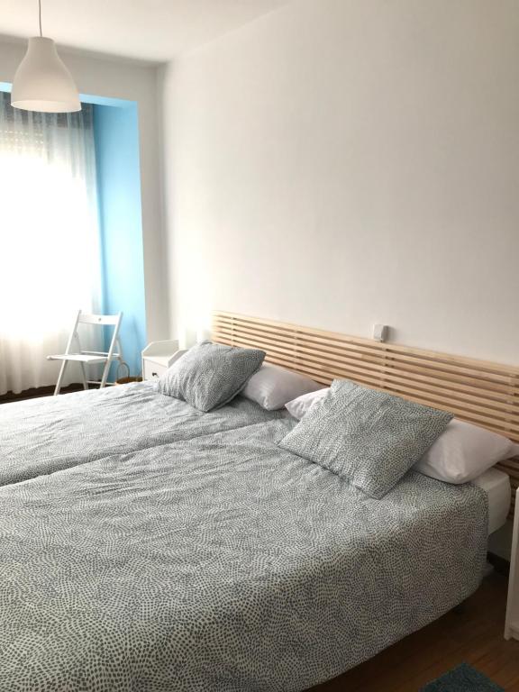 um quarto com uma cama com almofadas em Casa CHORIMA em Arzúa