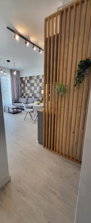 a large room with a wooden partition with a plant at KuuB Apartments in Constanţa