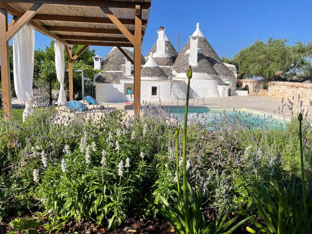a garden with flowers in front of a house at Trullo Matilde in Martina Franca