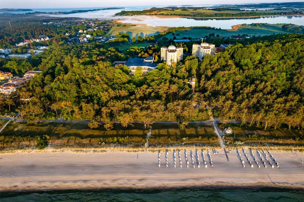 an aerial view of a beach with trees and a city at Cliff Hotel Rügen in Ostseebad Sellin