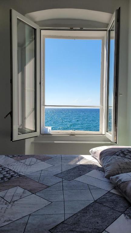 um quarto com uma grande janela com vista para o oceano em Apartment LOTI em Piran