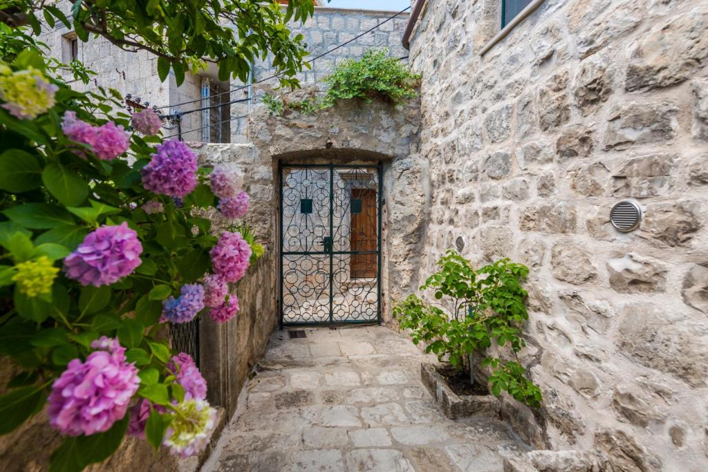 an entrance to a stone building with a door with purple flowers at Unique Cavtat Center Apartment in Cavtat