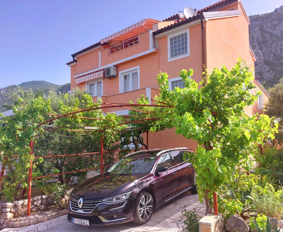un'auto parcheggiata di fronte a una casa di Apartman Sous les rochers a Grižane