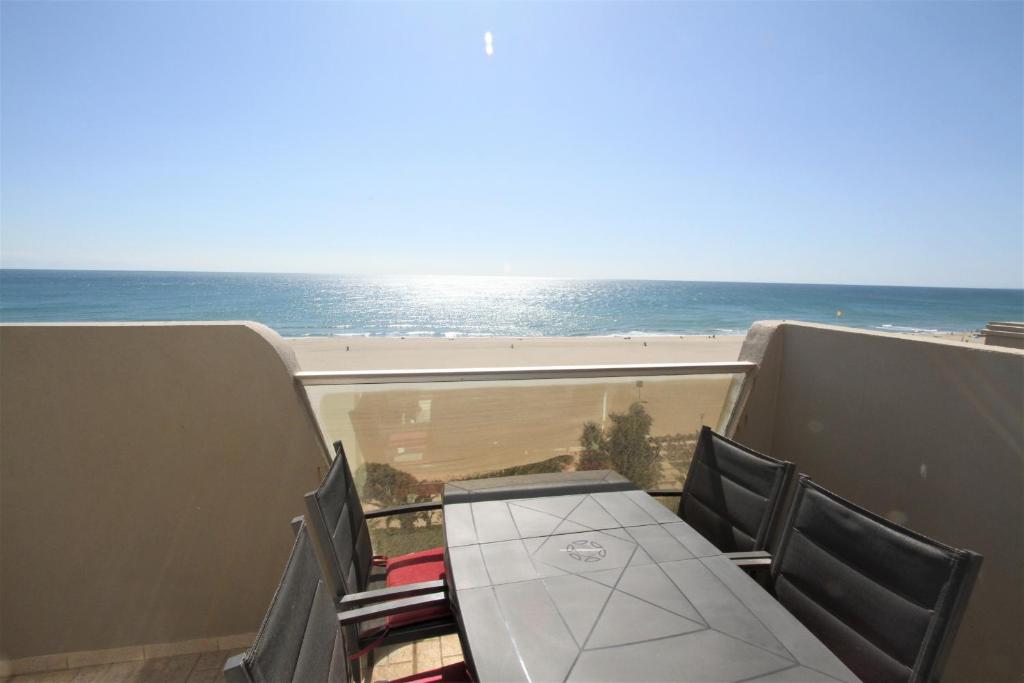 un balcon avec une table et des chaises et l'océan dans l'établissement Appartement 2 pieces en front de mer, à Canet