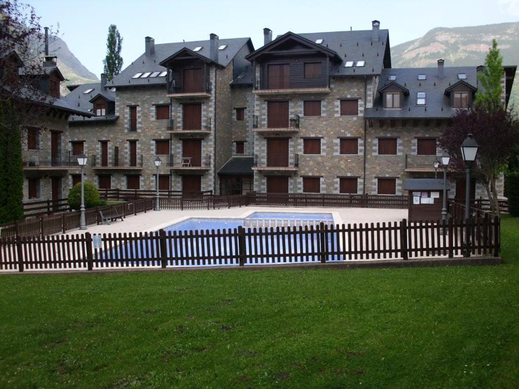 una valla frente a un gran edificio en Apartamentos Nevados 28311, en Anciles