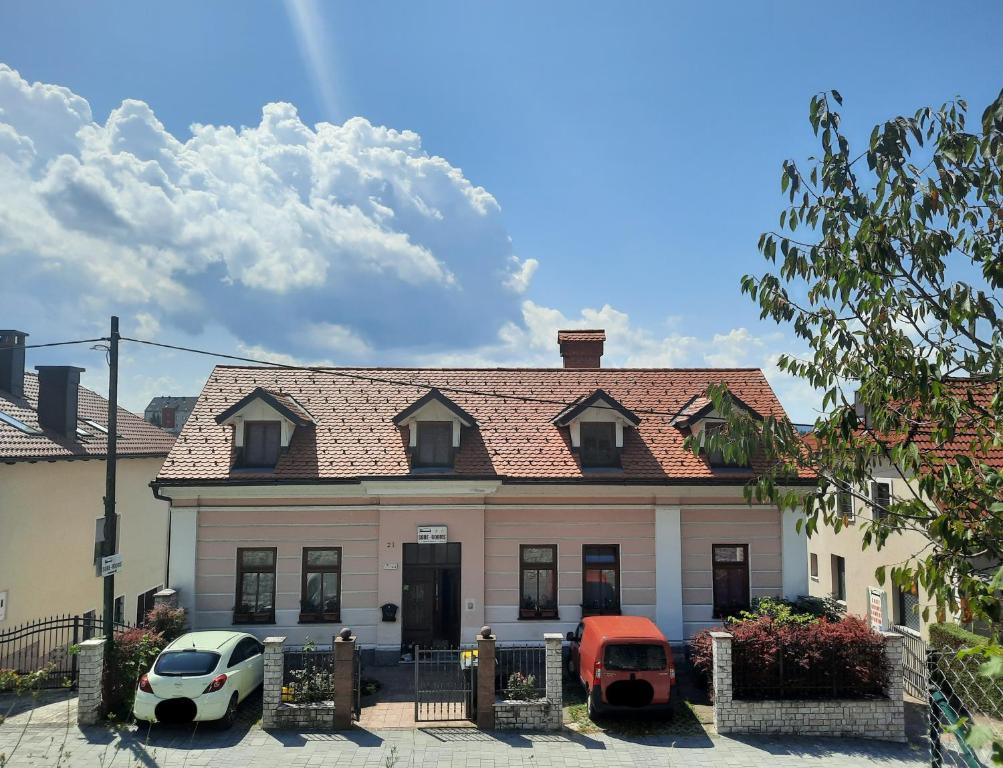 una casa con dos coches estacionados frente a ella en Rooms Čehovin en Postojna