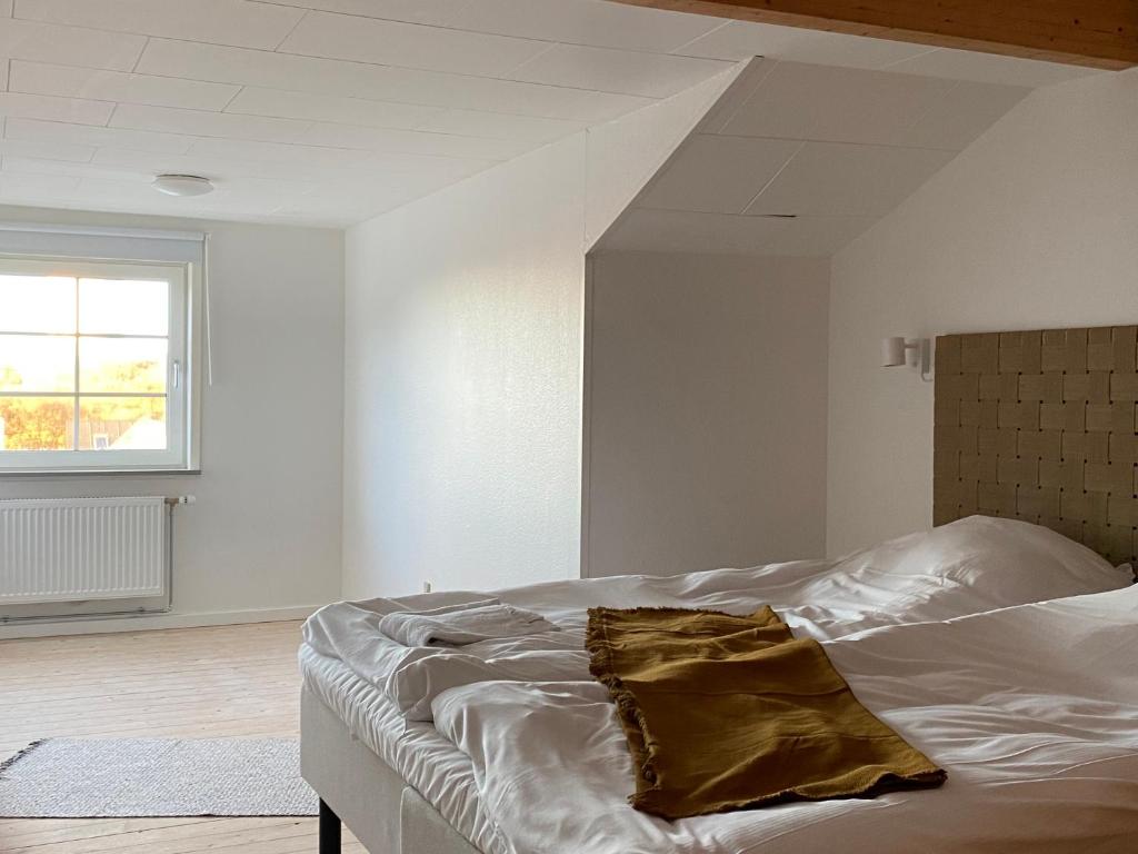 洛肯的住宿－Hotel Klitbakken，白色的卧室配有带枕头的床