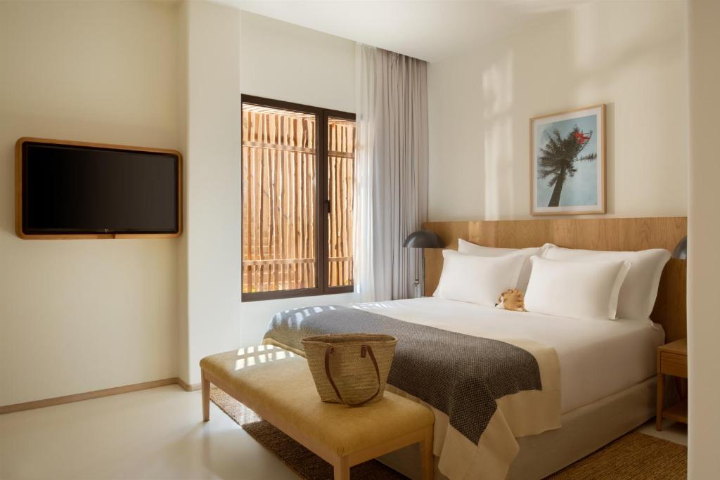 a hotel room with a bed and a tv at Six Senses Ibiza in Portinatx
