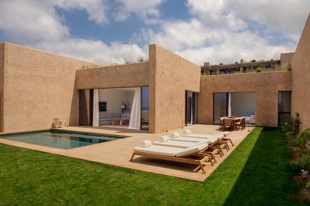 a backyard with a swimming pool and a house at Six Senses Ibiza in Portinatx
