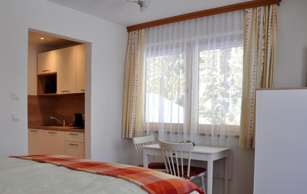 Schlafzimmer mit einem Bett, einem Tisch und einem Fenster in der Unterkunft Haus Kocher in Haus im Ennstal