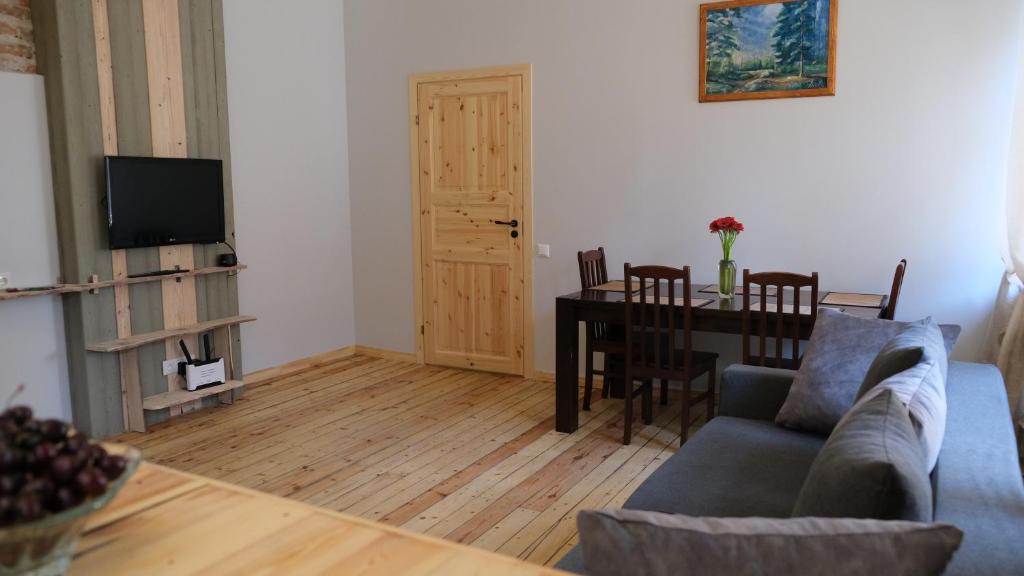 a living room with a couch and a dining room table at Historic apartment with Wooden floors in the Hearth of Old-town Riga in Rīga