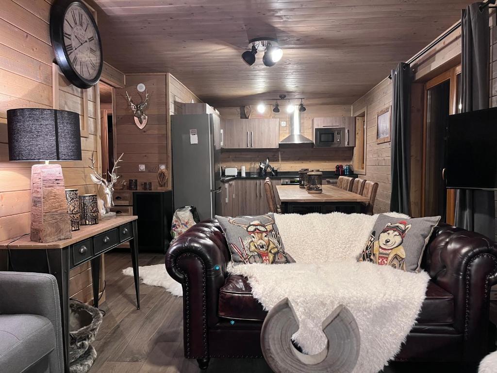 ein Wohnzimmer mit einem Sofa und einer Küche in der Unterkunft Instant Méribel in Les Allues