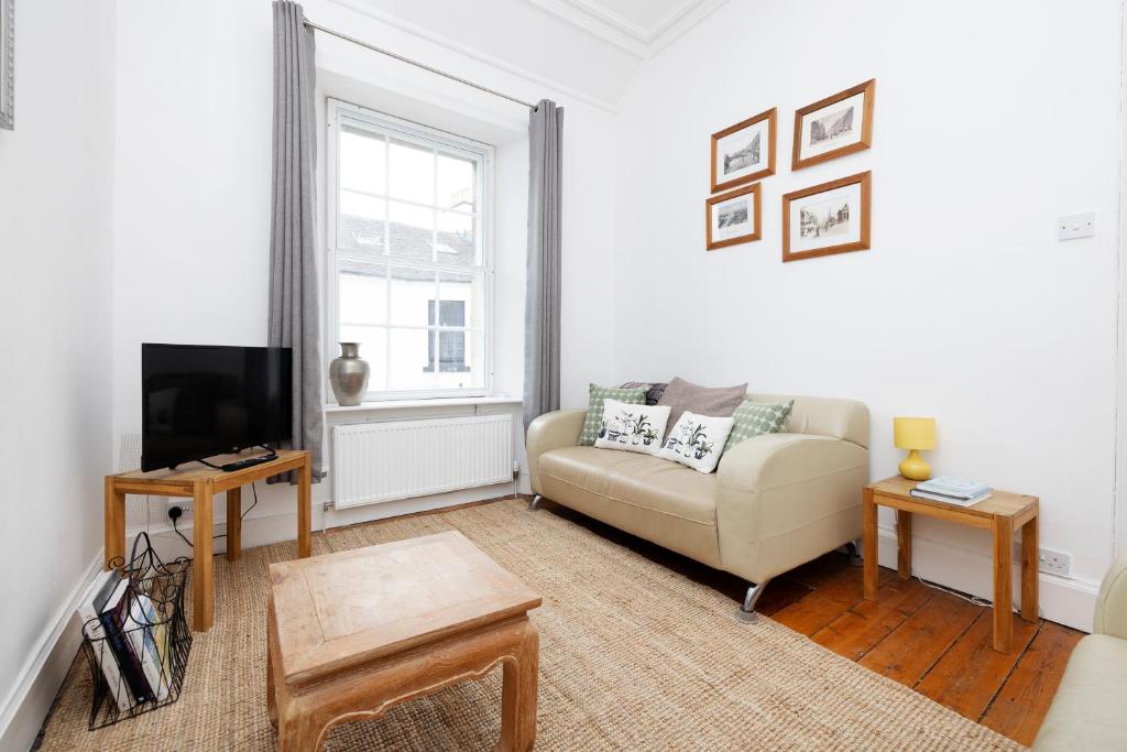 a living room with a couch and a tv at ALTIDO Cosy flat in the heart of Edinburgh in Edinburgh