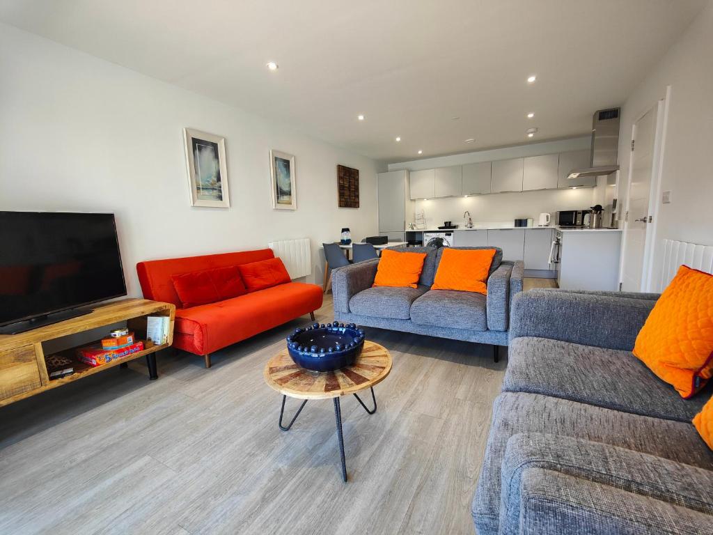 a living room with two couches and a television at 3 Putsborough - Luxury Apartment at Byron Woolacombe, only 4 minute walk to Woolacombe Beach! in Woolacombe