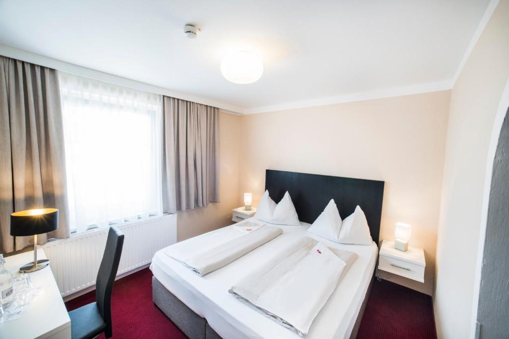 Een bed of bedden in een kamer bij Stadthotel Kramer