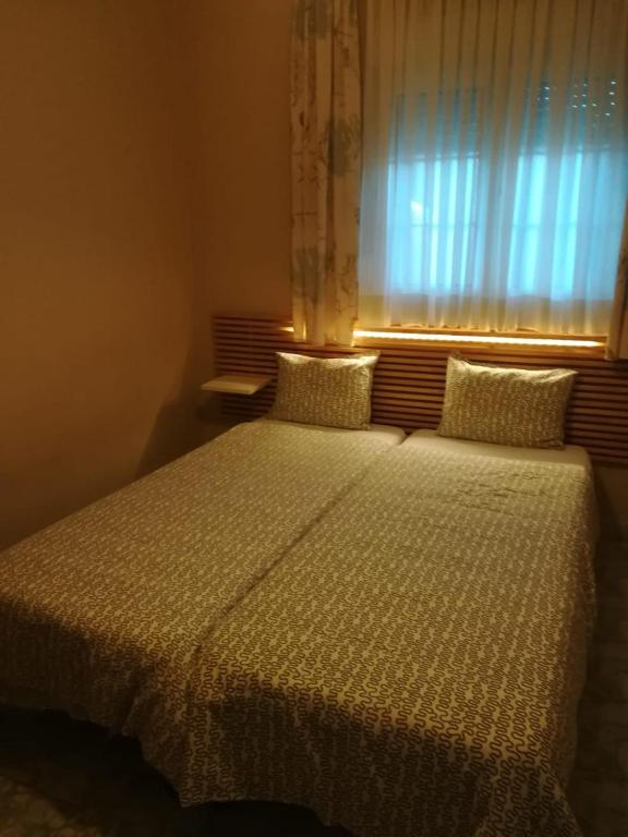 a bedroom with a large bed with a window at Seaview Aparthotel in Nea Potidaea