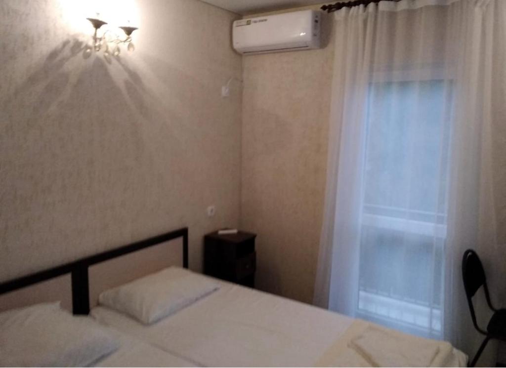 a bedroom with a bed and a window and a fan at Вилла Блюз in Novy Afon