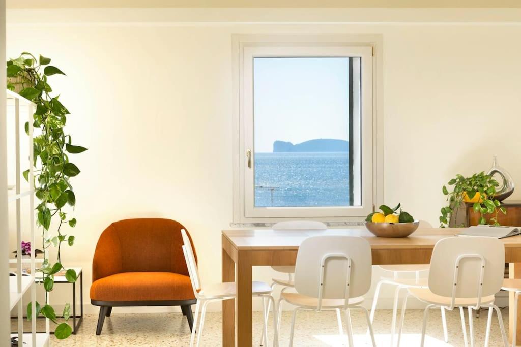 a dining room with a table and chairs and a window at Centro Storico, meravigliosa vista mare, 4' piano senza ascensore in Alghero