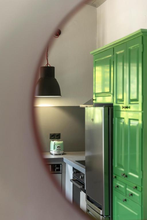 a kitchen with green cabinets and a refrigerator at Paleokastritsa Red Gate Flat in Paleokastritsa