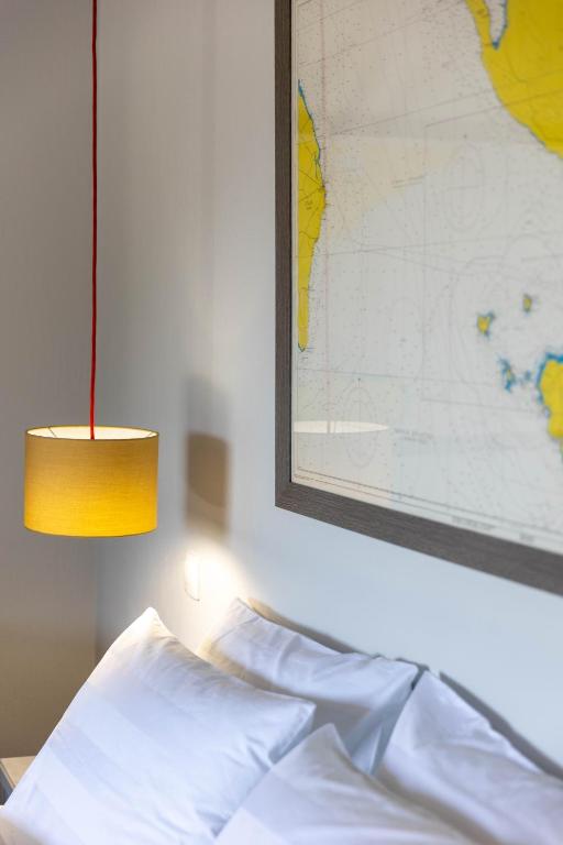 a bed with a yellow lamp and a map on the wall at Paleokastritsa Red Gate Flat in Paleokastritsa