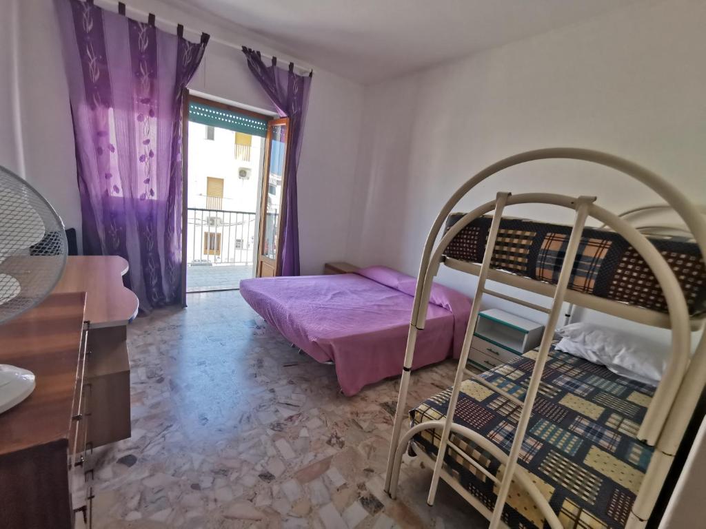 1 Schlafzimmer mit 2 Etagenbetten und lila Vorhängen in der Unterkunft Casa vacanze da Michela in Peschici