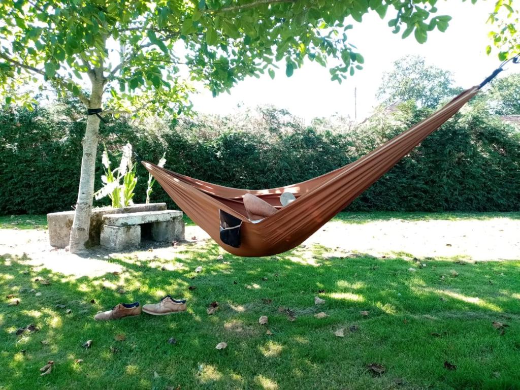 a person sleeping in a hammock in a park at Entre forêts et prairies in Le Cercueil