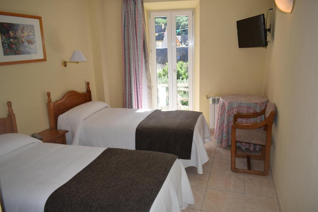 a hotel room with two beds and a window at Hotel Juan Canejan in Les