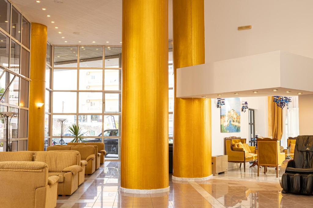 a lobby with yellow columns in a building at Santa Marina Unique Hotel in Agios Nikolaos