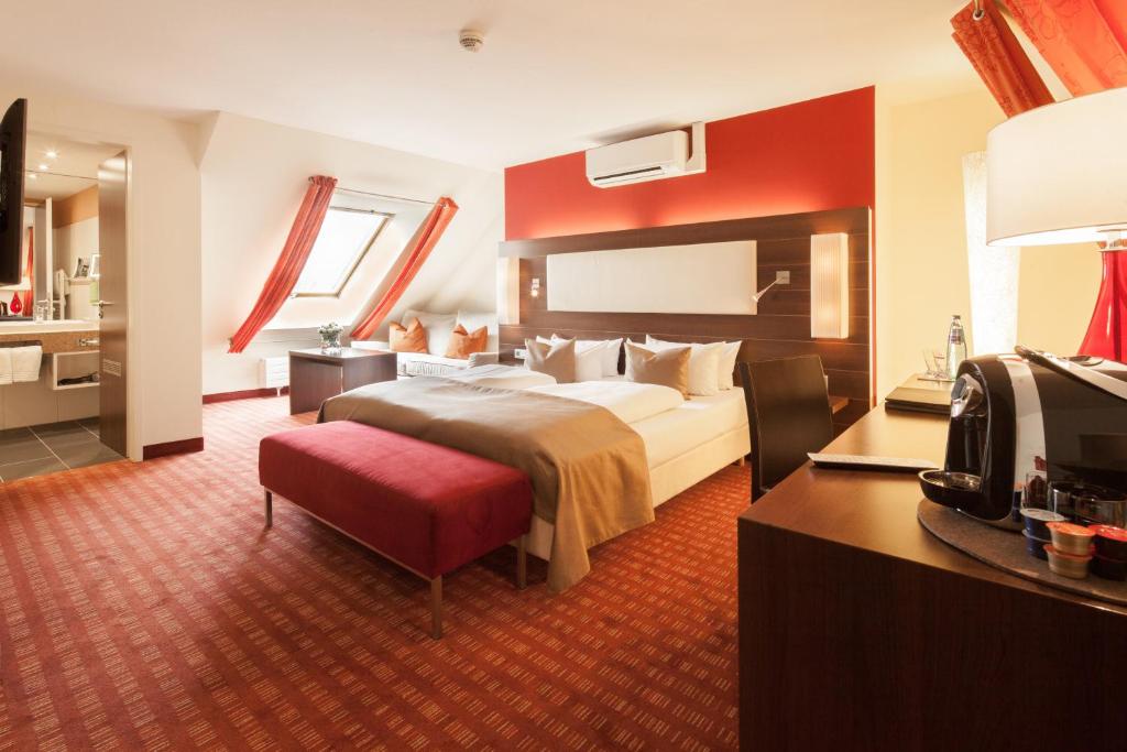 una camera d'albergo con letto e bagno di Designhotel am Stadtgarten a Friburgo in Brisgovia