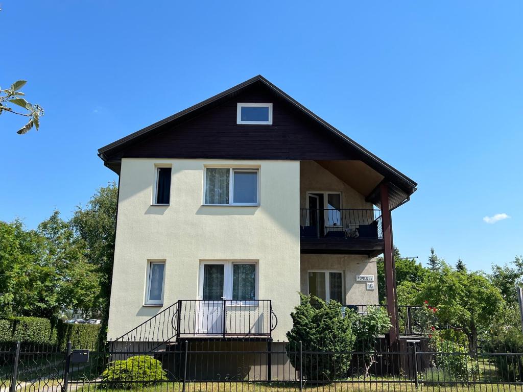 a large white house with a black roof at Topoliu 16 guesthouse in Šventoji