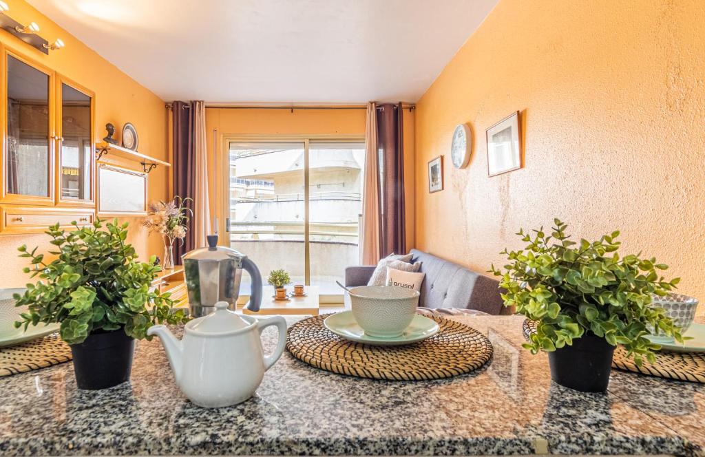 a living room with a table and two potted plants at Sevilla Arysal in Salou