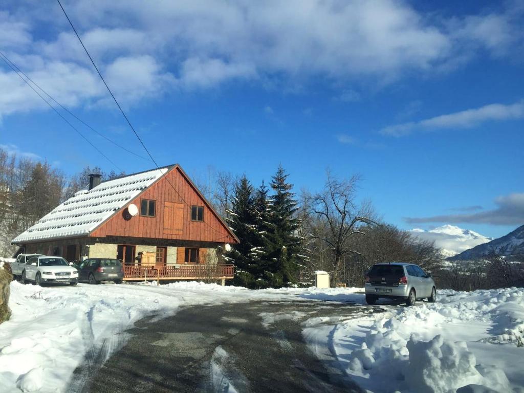 een houten huis met auto's in de sneeuw bij Maison de 4 chambres avec jardin amenage et wifi a Villarembert a 2 km des pistes in Villarembert