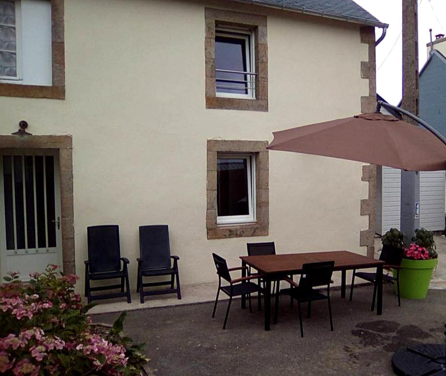 a table and chairs and an umbrella in front of a house at Maison de 2 chambres avec jardin amenage et wifi a Cast in Cast