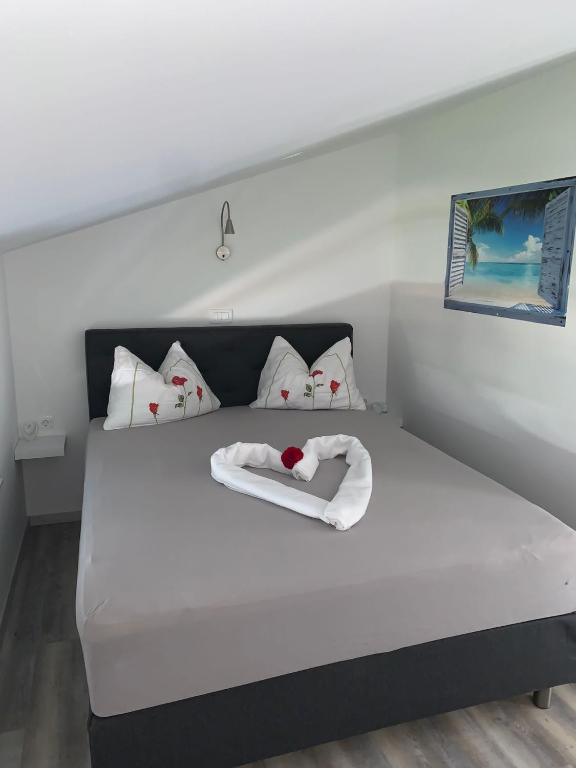 a large white bed with a heart on it at Appartement Vila Fajen in Sukošan