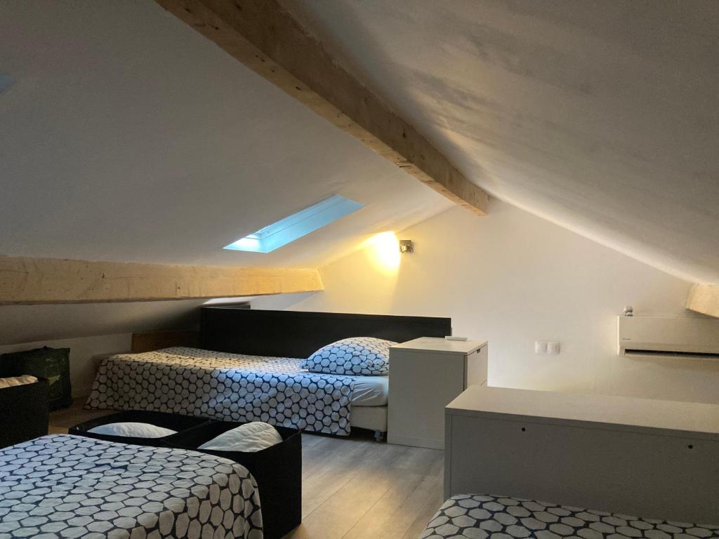une chambre avec deux lits dans un grenier dans l'établissement Maison de pêcheur 1900, à Saint-Mandrier-sur-Mer