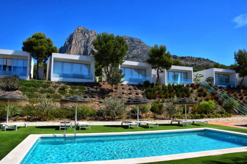 a villa with a swimming pool in front of a resort at Nature Suites Puig Campana by AR Hotels & Resorts in Finestrat