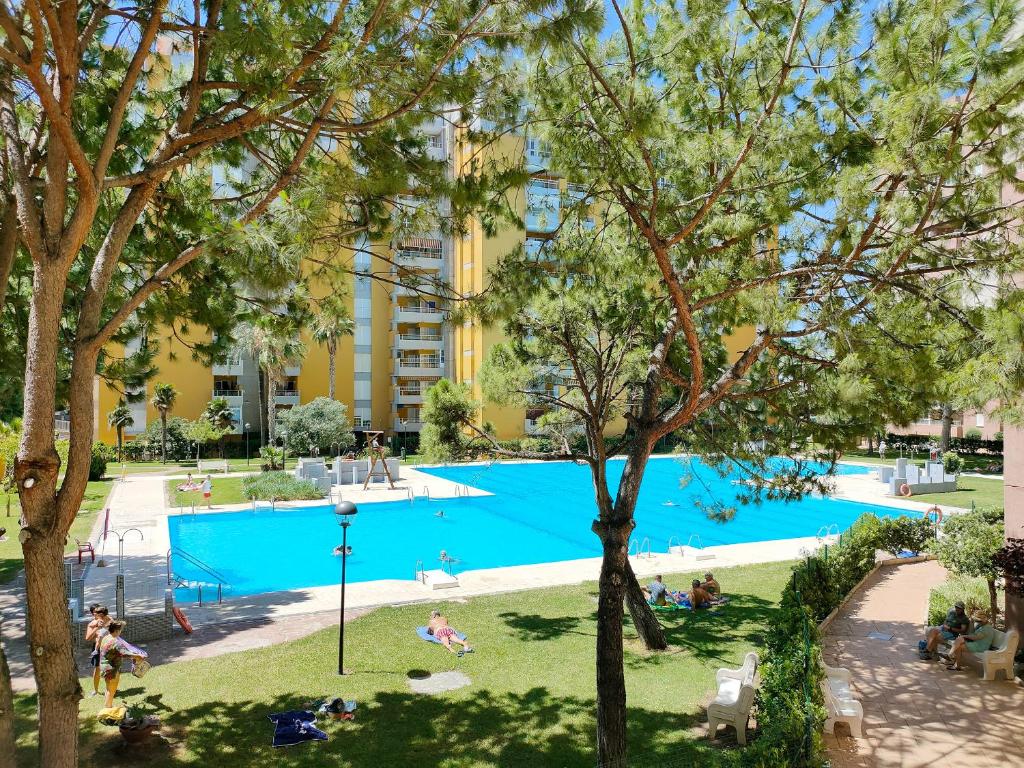 an image of a swimming pool in a park with trees at Global Properties, Apartamento con piscina en Residencial Brezo in Canet de Berenguer