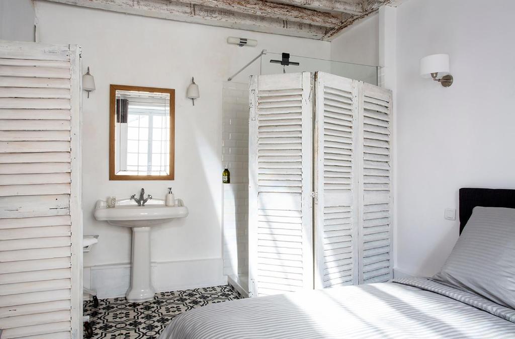 a white bathroom with a sink and a bed at Appartement Gérard, tout équipé Paris 13éme in Paris