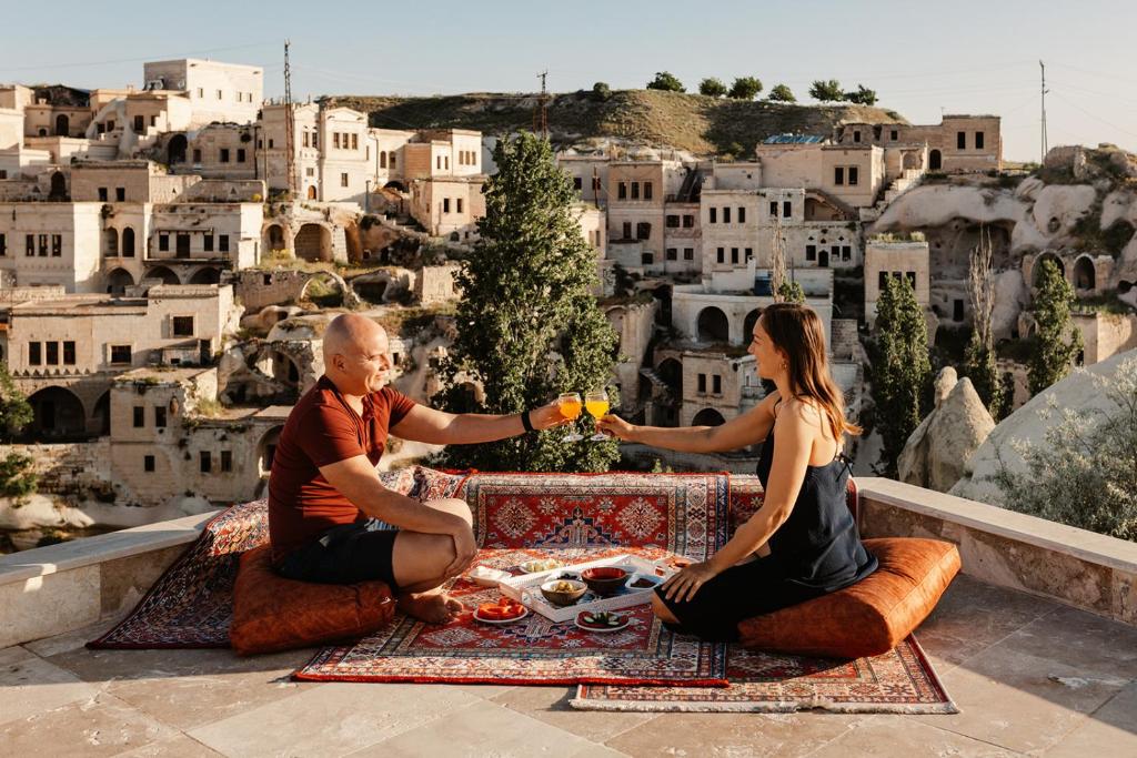 Een man en een vrouw die rond een tafel eten. bij Narcissos Cave Hotel in Urgup