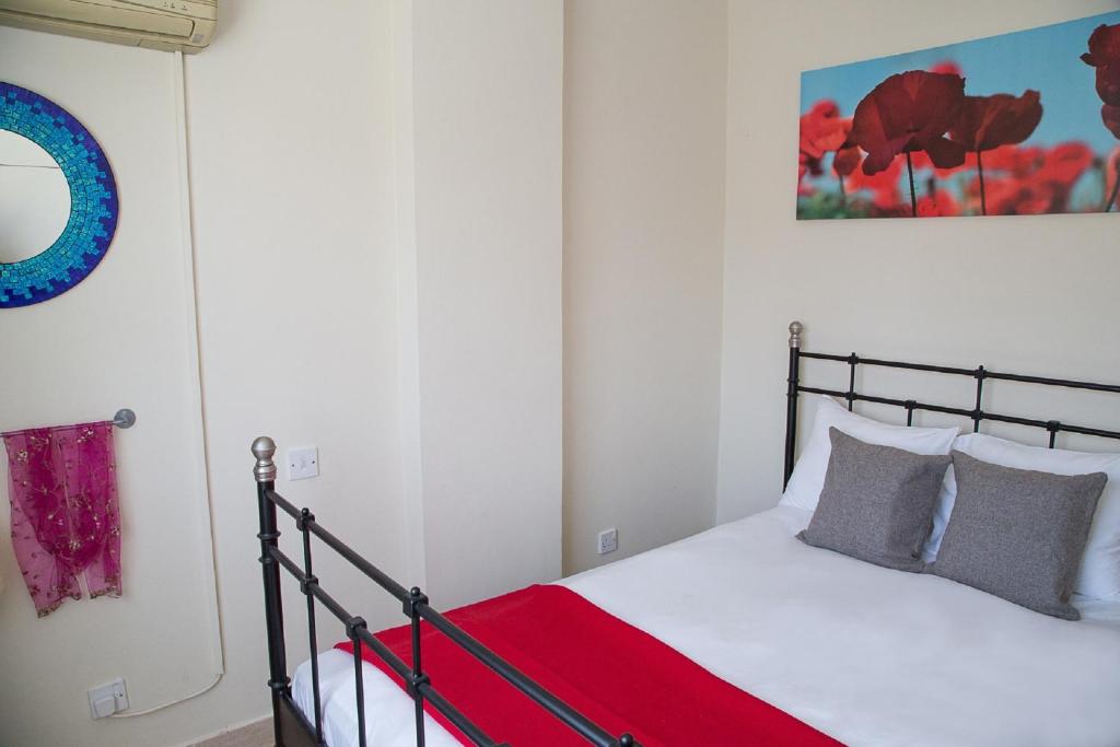 a bedroom with a bed with a red blanket at Paphos Love Nest Apartment in Paphos City
