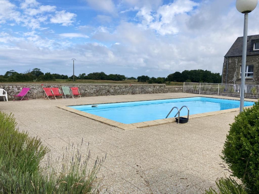 una piscina con sillas y una casa en Appartement d'une chambre avec piscine partagee et jardin clos a Montmartin sur Mer a 2 km de la plage en Montmartin-sur-Mer