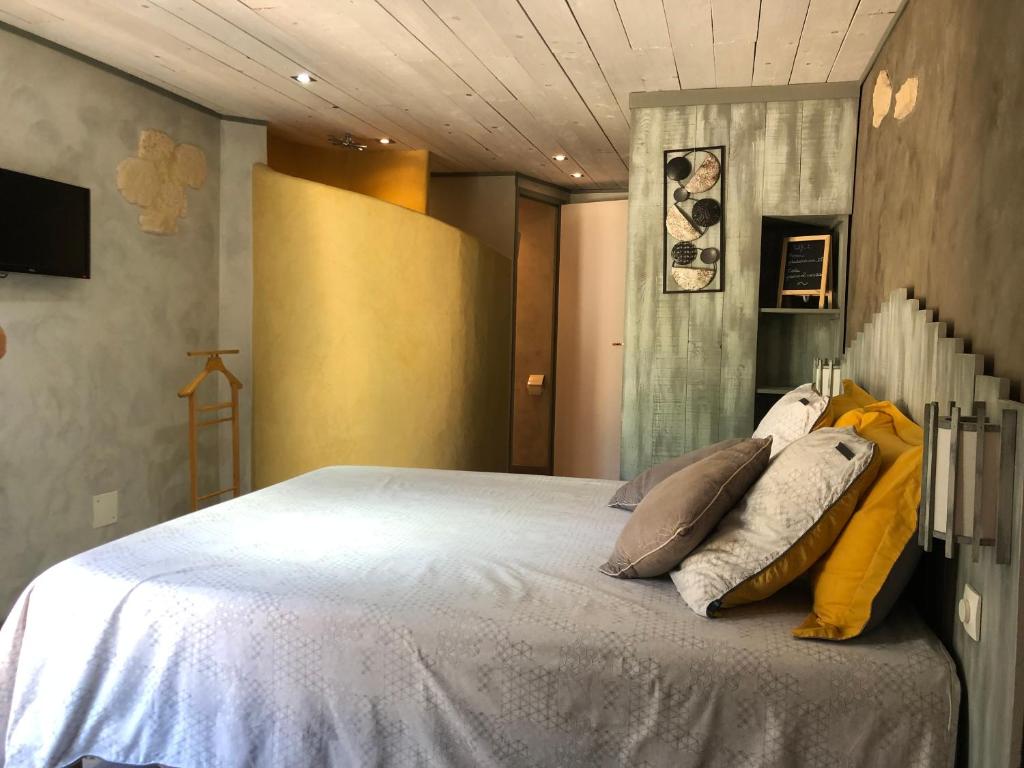 a bedroom with a bed with pillows on it at chambre d’hôtes des oliviers in La Roque-sur-Cèze